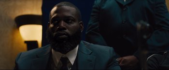 Movie still from “Bleed for This” (2016), directed by Ben Younger – A man in a suit with a beard; Close Up shot, Over the shoulder angle