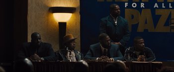 Movie still from “Bleed for This” (2016), directed by Ben Younger – A group of men sitting in front of each other; Medium shot, Over the shoulder angle