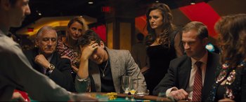 Movie still from “Bleed for This” (2016), directed by Ben Younger – A man sitting at a table in front of two women; Medium shot, High angle