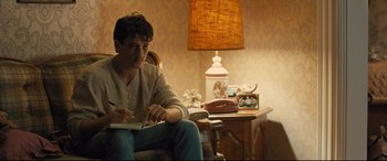 Movie still from “Bleed for This” (2016), directed by Ben Younger – A man sitting in a chair writing on a piece of paper; Medium shot, Over the shoulder angle