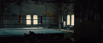 Movie still from “Bleed for This” (2016), directed by Ben Younger – An empty boxing ring in an abandoned boxing gym; Wide shot, Over the shoulder angle