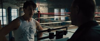 Movie still from “Bleed for This” (2016), directed by Ben Younger – A young man in a boxing ring looking at the camera; Medium shot, Over the shoulder angle