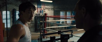 Movie still from “Bleed for This” (2016), directed by Ben Younger – A man standing in front of a boxing ring in a boxing ring; Medium shot, Over the shoulder angle