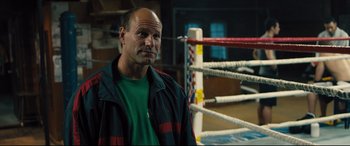 Movie still from “Bleed for This” (2016), directed by Ben Younger – A man standing in front of a boxing ring; Close Up shot, Over the shoulder angle