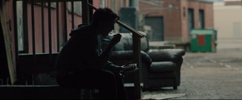 Movie still from “Bleed for This” (2016), directed by Ben Younger – A person sitting on a chair eating something; Medium shot, Over the shoulder angle