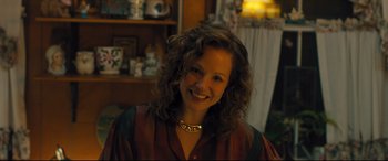 Movie still from “Bleed for This” (2016), directed by Ben Younger – A woman with curly brown hair smiling for the camera; Close Up shot, High angle
