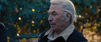 Movie still from “Bleed for This” (2016), directed by Ben Younger – An older man with white hair sitting on a park bench; Close Up shot, Over the shoulder angle