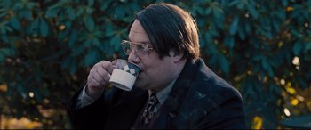 Movie still from “Bleed for This” (2016), directed by Ben Younger – A man in a suit drinking a cup of coffee; Close Up shot, Over the shoulder angle
