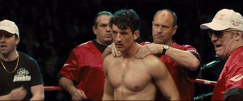 Movie still from “Bleed for This” (2016), directed by Ben Younger – A man with his hands on his shoulders and another man with his hands on his chest; Medium shot, Over the shoulder angle