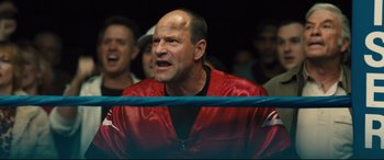 Movie still from “Bleed for This” (2016), directed by Ben Younger – A man wearing a red jacket in a boxing ring; Close Up shot, Over the shoulder angle