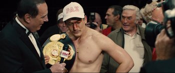 Movie still from “Bleed for This” (2016), directed by Ben Younger – A man in a white hat is holding a boxing glove; Medium shot, Over the shoulder angle
