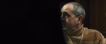 Movie still from “Bleed for This” (2016), directed by Ben Younger – A man's face in a dark room; Close Up shot, Over the shoulder angle