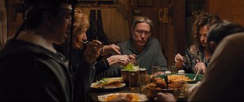 Movie still from “Bleed for This” (2016), directed by Ben Younger – A group of people sitting at a dinner table eating food; Medium shot, Over the shoulder angle