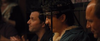 Movie still from “Bleed for This” (2016), directed by Ben Younger – A man with a beard and a wig on his head and a man with a beard and a wig on his head; Close Up shot, Over the shoulder angle