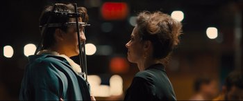 Movie still from “Bleed for This” (2016), directed by Ben Younger – A woman standing next to a man in front of lights; Close Up shot, Over the shoulder angle