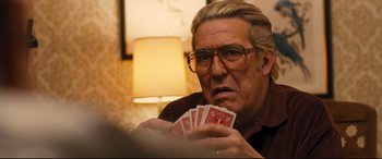 Movie still from “Bleed for This” (2016), directed by Ben Younger – A man holding a deck of playing cards in his hands; Close Up shot, Over the shoulder angle
