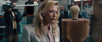 Movie still from “Bleed for This” (2016), directed by Ben Younger – A woman with blonde hair wearing a suit and tie; Close Up shot, Over the shoulder angle