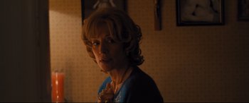 Movie still from “Bleed for This” (2016), directed by Ben Younger – An older woman is standing in a dark room; Close Up shot, Over the shoulder angle