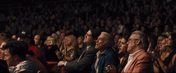 Movie still from “Bleed for This” (2016), directed by Ben Younger – A group of people sitting in front of an audience; Medium shot, Over the shoulder angle