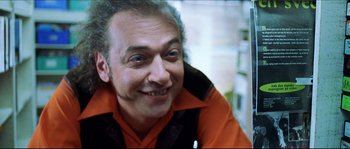 Movie still from “Bleeder” (1999), directed by Nicolas Winding Refn – A person wearing an orange and black shirt; Close Up shot, Low angle