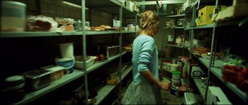 Movie still from “Bleeder” (1999), directed by Nicolas Winding Refn – A woman standing in a kitchen holding a cup; Medium shot, High angle