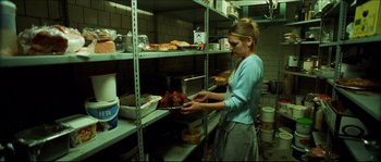 Movie still from “Bleeder” (1999), directed by Nicolas Winding Refn – A woman is holding a tray of food in a kitchen; Medium shot, High angle