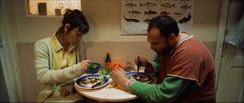 Movie still from “Bleeder” (1999), directed by Nicolas Winding Refn – A man and a woman sitting at a dinner table; Medium shot, Overhead angle