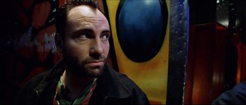 Movie still from “Bleeder” (1999), directed by Nicolas Winding Refn – A person wearing a black jacket; Close Up shot, Low angle