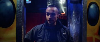 Movie still from “Bleeder” (1999), directed by Nicolas Winding Refn – A man in a black jacket standing in front of a mirror; Close Up shot, Low angle