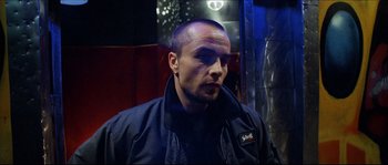 Movie still from “Bleeder” (1999), directed by Nicolas Winding Refn – A person wearing a jacket; Close Up shot, Low angle