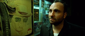 Movie still from “Bleeder” (1999), directed by Nicolas Winding Refn – A person in front of a picture; Close Up shot, Low angle