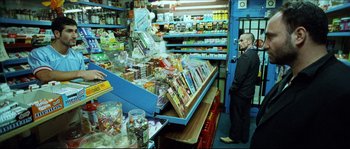 Movie still from “Bleeder” (1999), directed by Nicolas Winding Refn – A man standing in front of a display case in a grocery store; Wide shot, High angle