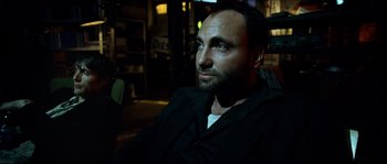 Movie still from “Bleeder” (1999), directed by Nicolas Winding Refn – A person sitting in a chair; Close Up shot, Over the shoulder angle