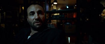 Movie still from “Bleeder” (1999), directed by Nicolas Winding Refn – A person sitting in a room; Close Up shot, Low angle