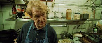 Movie still from “Bleeder” (1999), directed by Nicolas Winding Refn – A man in an apron in a kitchen; Close Up shot, Low angle