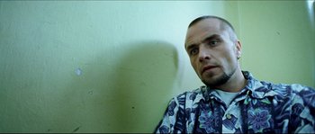 Movie still from “Bleeder” (1999), directed by Nicolas Winding Refn – A person wearing a floral shirt; Close Up shot, Low angle