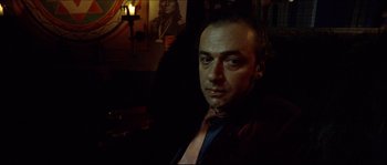 Movie still from “Bleeder” (1999), directed by Nicolas Winding Refn – A person wearing a suit and tie; Close Up shot, Low angle