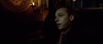 Movie still from “Bleeder” (1999), directed by Nicolas Winding Refn – A person wearing a suit and tie; Close Up shot, Over the shoulder angle