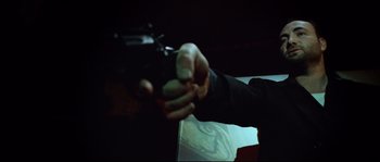 Movie still from “Bleeder” (1999), directed by Nicolas Winding Refn – A person holding a gun in their hand; Close Up shot, Low angle