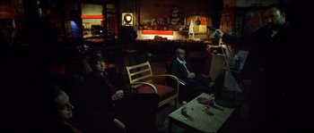Movie still from “Bleeder” (1999), directed by Nicolas Winding Refn – A group of people sitting in a living room watching tv; Wide shot, High angle
