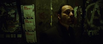 Movie still from “Bleeder” (1999), directed by Nicolas Winding Refn – A man in a suit standing next to a wall; Close Up shot, Low angle