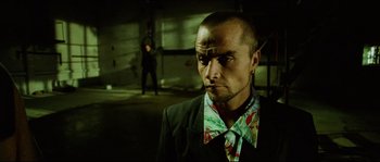 Movie still from “Bleeder” (1999), directed by Nicolas Winding Refn – A man in a suit and tie standing next to another man in a suit and tie; Close Up shot, Low angle