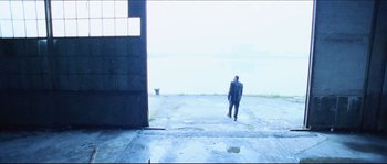 Movie still from “Bleeder” (1999), directed by Nicolas Winding Refn – A man in a business suit walking by the water; Extreme Wide shot, High angle