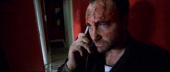 Movie still from “Bleeder” (1999), directed by Nicolas Winding Refn – A man with blood all over his face talking on a cell phone; Close Up shot, Low angle