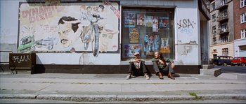 Movie still from “Bleeder” (1999), directed by Nicolas Winding Refn – Two men sitting on the side of the street; Wide shot, Low angle