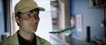 Movie still from “Bleeder” (1999), directed by Nicolas Winding Refn – A person wearing a hat; Close Up shot, Over the shoulder angle