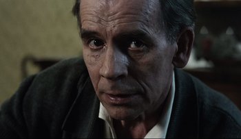 Movie still from “Blind Chance” (1987), directed by Krzysztof Kieslowski – An older man with a sad look on his face; Close Up shot, Over the shoulder angle