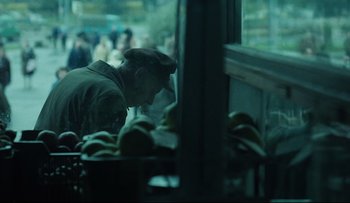 Movie still from “Blind Chance” (1987), directed by Krzysztof Kieslowski – A man in a hat is looking at some food in a restaurant; Medium shot, Over the shoulder angle