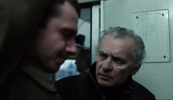 Movie still from “Blind Chance” (1987), directed by Krzysztof Kieslowski – A man with gray hair is looking at another man in a black jacket; Close Up shot, Over the shoulder angle