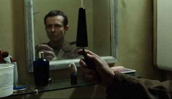 Movie still from “Blind Chance” (1987), directed by Krzysztof Kieslowski – A man looking in the mirror while holding a hair brush; Close Up shot, Over the shoulder angle